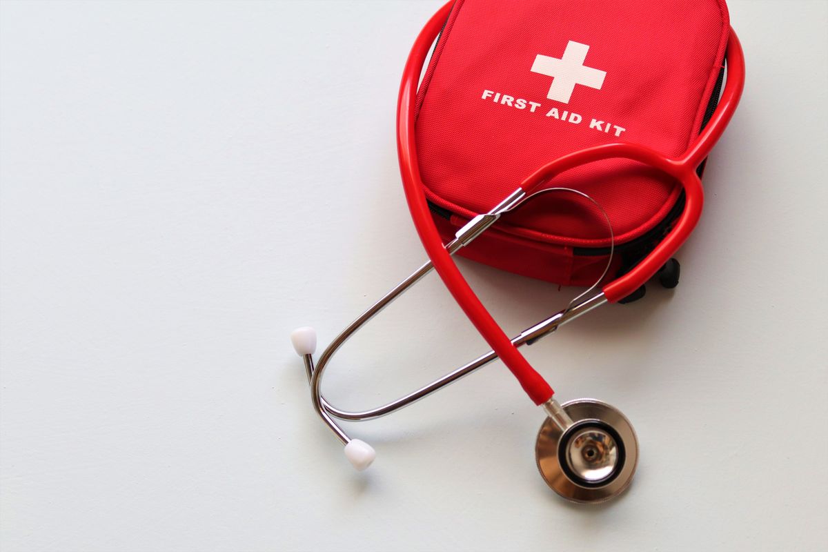 Red first-aid kit and stethoscope on a light background